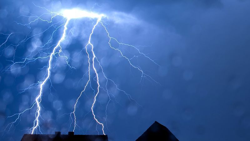 Blitze über einem Haus, © dpa
